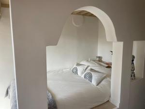 普罗旺斯艾克斯Le Mini - Un voyage en Provence的卧室内一张带拱门的白色床