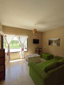 卡法亚特La Morada Hostal的客厅设有绿色沙发和窗户。
