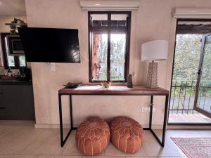 SanteaguedaLoft Amalfi en Val'Quirico的客厅里一张桌子和两张脚凳