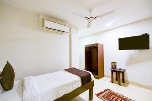 新德里Hotel Amenda Delhi IGI Airport International Mahipalpur的一间卧室配有一张床和一台平面电视