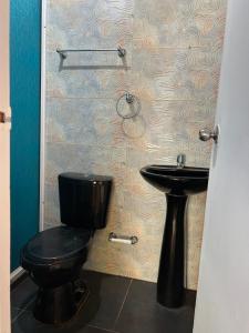 Playa Punta ArenaPunta Arena EcoHostal & EcoFit - Your Eco-Friendly Oasis 02的浴室设有黑色的卫生间和水槽。