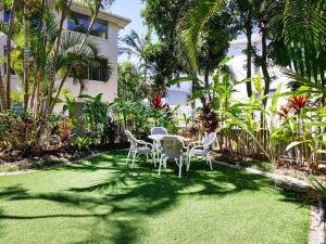 黄金海岸Maimi renovated 2-bedroom apartment的院子里草地上的桌椅