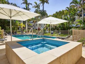 黄金海岸Maimi renovated 2-bedroom apartment的一个带遮阳伞和游泳池的大型游泳池