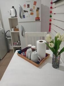 布宜诺斯艾利斯Departamento Villa Urquiza的厨房柜台,托盘上放有碗碟,花瓶上放着花