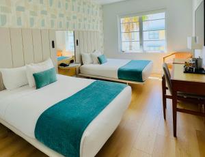 迈阿密海滩阿瓦隆酒店的酒店客房配有两张床、一张书桌和一张书桌。