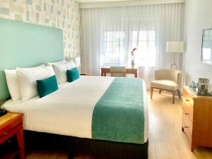 迈阿密海滩阿瓦隆酒店的一间卧室配有一张带蓝色和绿色床单的大床