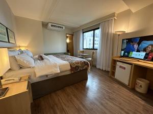 巴西利亚Lets Idea Brasilia Hotel - Flat Particular的配有一张床和一台平面电视的酒店客房