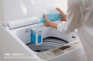 广岛bHOTEL Heiwaoodori 401 - Brand New Apt Famous Hiroshima Dori 6ppl的一个人在把东西放进洗衣机里