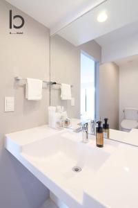 广岛bHOTEL Heiwaoodori 601 - New Apt In Famous Hiroshima Dori For 6p的白色的浴室设有水槽和镜子