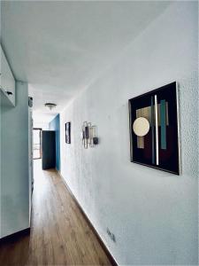 德尔锡伦西奥海岸Sasha Tenerife的一条带白色墙壁的走廊,上面有照片