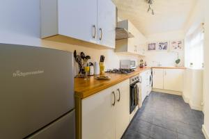 利物浦Liverpool City Haven-Dane Street的厨房配有白色橱柜和冰箱。