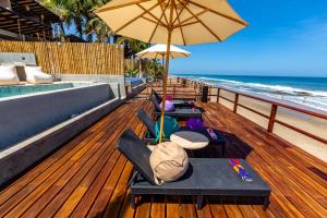 曼克拉Casa Colibrí的一个带椅子和遮阳伞的甲板和海滩