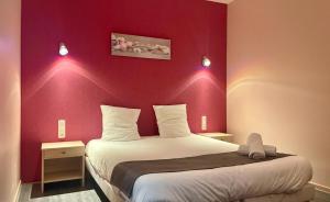 埃苏瓦Hôtel Les Demoiselles的一间卧室设有一张红色墙壁的大床