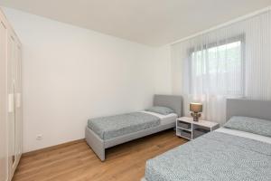 奈维斯Apartments and rooms with parking space Njivice, Krk - 17010的一间卧室设有两张床和窗户。