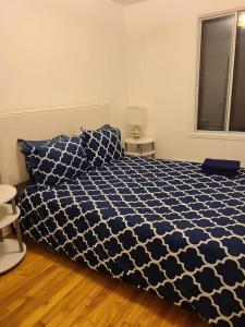 蒙特利尔425$ 7nights // Full Kitchen // Room B的卧室配有蓝色和白色的被子。