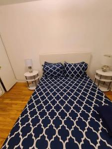 蒙特利尔425$ 7nights // Full Kitchen // Room B的卧室配有蓝色和白色的床和两张桌子
