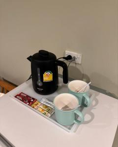 普吉镇普吉岛思礼酒店的茶壶和柜台上的两个杯子