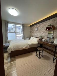 Irifunechōシャルムイースト的一间卧室设有一张床和砖墙