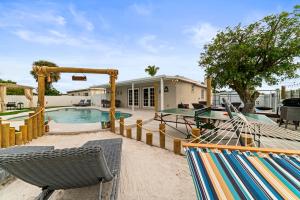 西棕榈滩Paradise Villa的后院设有游泳池、椅子和房屋