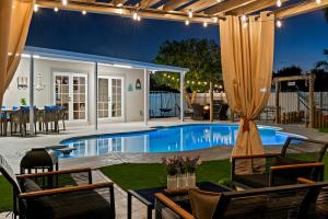 西棕榈滩Paradise Villa的一个带桌椅的游泳池和一个庭院