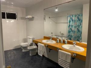 安加罗阿Manureva Nui Hotel Boutique的浴室设有2个水槽、卫生间和镜子。