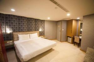 屏东县进成旅社 的卧室配有一张白色大床