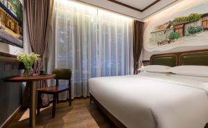 成都时光漫步S酒店（成都宽窄巷子店）的一间卧室配有一张床、一张桌子和一个窗户。