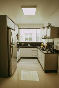 南卡希亚斯Ap completo melhor localização! Centro de Caxias.的厨房配有白色橱柜和冰箱。