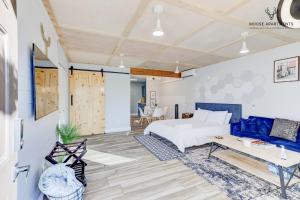孟菲斯The Moose at Memphis Downtown & Victorian Village的卧室配有白色的床和蓝色的沙发