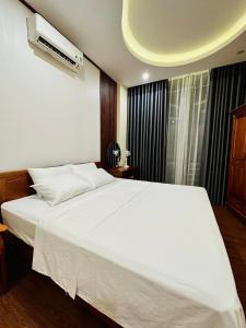 Tuyên QuangTuan Anh Hostel的卧室配有一张白色大床和空调。