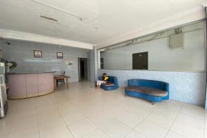 BagamOYO 93781 Hotel California 2的坐在等候室蓝色沙发上的人