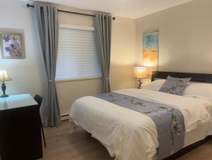 高贵林港Coquitlam center, 2 bedroom suite, walking to skytrain的一间卧室设有一张大床和一个窗户。