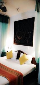 哈伯勒内Lihini Scandic Eco Village的一间卧室配有一张带两个黄色枕头的床