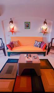 拉斯苏德尔La Hacienda ras sedr chalet的客厅配有橙色沙发和桌子