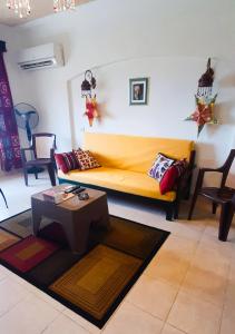 拉斯苏德尔La Hacienda ras sedr chalet的客厅配有黄色的沙发和桌子