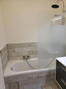 SoigniesLes gîtes du Ravel的浴室设有浴缸和水龙头