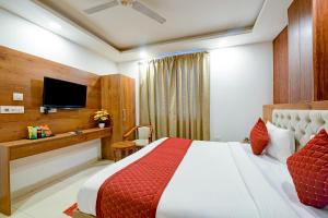 新德里Hotel Grand Qubic Near Delhi Airport的一间酒店客房,配有一张床和一台电视