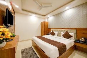 新德里Hotel Grand Qubic Near Delhi Airport的一间卧室配有一张大床和电视