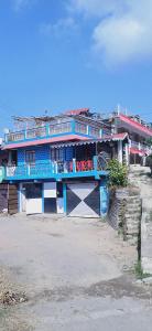 KurseongShriya Homestay的蓝色的建筑,上面设有阳台