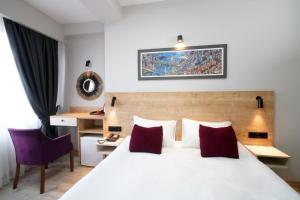 伊斯坦布尔Meet İstanbul Hotel Kadikoy的卧室配有带红色枕头的大型白色床