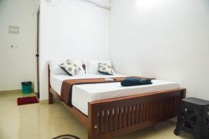 埃尔讷古勒姆SIYA RESIDENCY的一间卧室配有带白色床单和枕头的床。