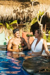 吉利特拉旺安Mango Tree House的男人和女人在游泳池里喝啤酒
