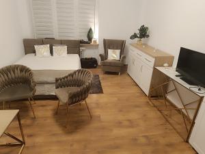什切青Apartamenty Magvel Gold的一间卧室配有一张床、两把椅子和一张书桌