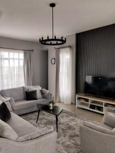 纳纽基Swara Ranch Nanyuki的客厅配有两张沙发和一台电视