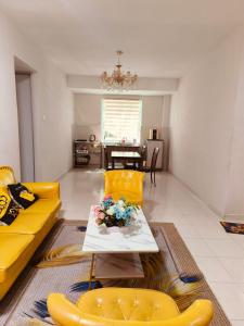 Kampong Malim NawarThe Trails Kampar的客厅配有黄色的沙发和桌子
