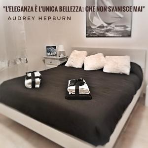雷诺河畔卡萨莱基奥La Terrazza sul Reno的一张大床,上面有黑色床单和白色毛巾