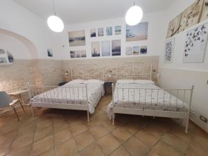 卡尔塔吉罗Trio D'Archi - La Maison de Cocò的墙上有两张照片的房间的床铺