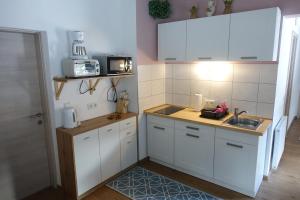 KirchbachApartmenthaus Kestel的小厨房配有白色橱柜和水槽