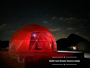 瓦迪拉姆Wadi rum anwar luxury camp的夜晚点亮红色圆顶