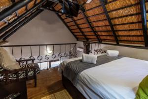 焦济尼Ndumu River Lodge的一间卧室,卧室内配有一张床和一把椅子
